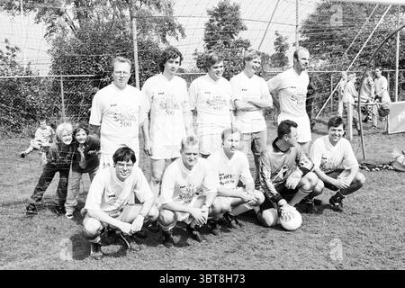 EDO-Fußballmannschaft Haarlem the Netherlands, Whizgle News, Dutch Desk, Niederlande, 1950 - 2000 auf 30-08-1997. Die Abbildung zeigt diese Themen. Die Szene zeigt eine Gruppe von Einzelpersonen, die auf einem grasbewachsenen Feld posiert, wahrscheinlich bei einem Sportereignis, insbesondere bei einem Fußballspiel. Die Umgebung deutet auf eine freundliche, gemeinschaftliche Atmosphäre mit einem Hintergrund von hohen Bäumen hin, was auf eine offene, natürliche Lage hindeutet. Im Vordergrund ist eine Mannschaft von Männern in zwei Reihen angeordnet: Die hintere Reihe besteht aus vier stehenden Spielern, während die erste Reihe fünf sitzende Spieler in sportlicher Freizeitkleidung hat. Jeder Spieler trägt ein passendes T Stockfoto