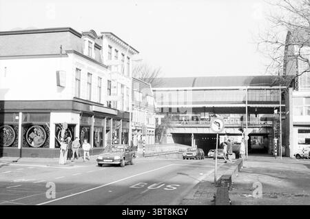 EXT. Restaurant Chang Au Kruisweg Haarlem Restaurant Haarlem Kruisweg Niederlande, Whizgle News, Dutch Desk, Niederlande, 1950 - 2000 am 08-02-1989. Dies sind die Themen im Bild. Die Szene zeigt eine geschäftige urbane Kreuzung, die durch eine Mischung aus Architektur und Aktivität gekennzeichnet ist. Auf der einen Seite steht ein zweistöckiges Gebäude mit großen Fenstern, die dekorative Elemente, möglicherweise Kunst oder Ausstellungen, zeigen. Die Fassade hat eine Mischung aus dunklen Farben mit Akzenten, die auf einen Vintage-Stil hinweisen könnten, was die Aufmerksamkeit auf seine bedeutende Präsenz lenkt. Im Vordergrund läuft eine Straße hori Stockfoto