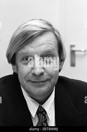 Telstar-Vorstandsmitglieder, Whizgle News, Dutch Desk, Niederlande, 1950 - 2000 am 17-11-1995. Dies sind die Elemente im Bild. Die Szene zeigt eine Person mit kurzen, hellen Haaren, die glatt gestylt sind. Der Ausdruck der Person ist freundlich und ansprechbar, gekennzeichnet durch ein sanftes Lächeln, das ein Gefühl der Wärme offenbart. Sie tragen einen formellen dunklen Anzug, begleitet von einem hellen Hemd und einer gemusterten Krawatte, die der Kleidung einen Hauch von Eleganz verleiht. Der Hintergrund besteht aus einem neutralen Ton, möglicherweise einer Wand, der die Anwesenheit des Motivs nicht ablenkt. Stockfoto