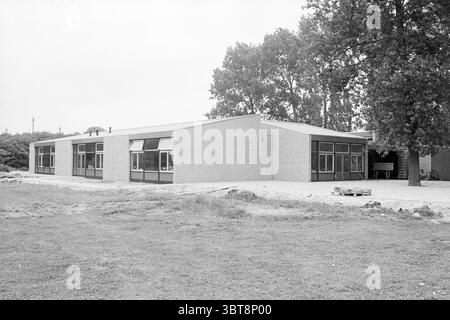 Exterieur Training School IJmuiden Exterieur Schools IJmuiden the Netherlands, Whizgle News, Dutch Desk, Niederlande, 1950 - 2000 am 01-07-1981. Dies sind die Elemente im Bild. Die Szene verfügt über ein modernes Gebäude, das sich durch seinen minimalistischen architektonischen Stil auszeichnet. Das Gebäude besteht überwiegend aus hellem Ziegelstein mit flachem Dach und einer Reihe von großen Glasfenstern, die ein Gefühl von Offenheit und Verbindung nach außen schaffen. Das Gebäude ist leicht außermittig positioniert, was den Blick auf die klaren Linien und kantigen Formen seines Designs lenkt. Um die bui herum Stockfoto
