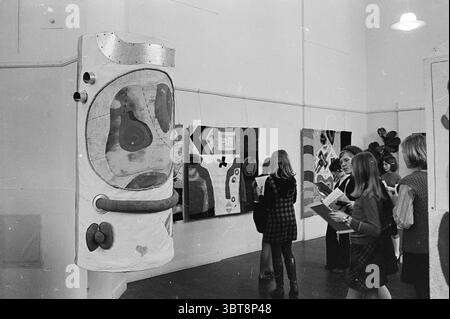 Ausstellung Felison Tapisserien Ausstellungen, Whizgle News, Dutch Desk, Niederlande, 1950 - 2000 am 25-02-1969. Diese Themen sind in der Abbildung dargestellt. Die Szene zeigt eine Kunstausstellung in einer geräumigen, gut beleuchteten Galerie. Die Wände sind mit verschiedenen abstrakten Kunstwerken verziert, die jeweils eine lebendige Mischung aus Formen und Farben zeigen, darunter kräftige Rot-, Blau-, Gelb- und Grüntöne, schaffen Sie eine lebendige Atmosphäre. Im Vordergrund hängt eine große, skulpturale Installation, die einem überdimensionalen Astronauten oder einer Raumkapsel ähnelt. Dieses Modell zeichnet sich durch sein einzigartiges Design mit abgerundetem bo aus Stockfoto