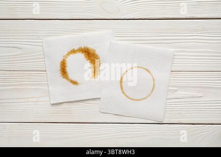 Papierservietten mit Kaffeeflecken auf weißem Holzhintergrund Stockfoto