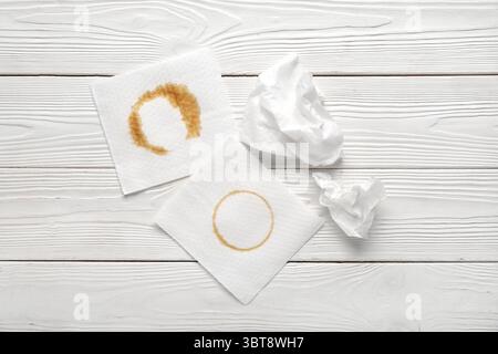 Papierservietten mit Kaffeeflecken auf weißem Holzhintergrund Stockfoto