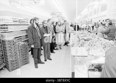 Eröffnung DEKA Market Schalkwijk Eröffnungen Inbetriebnahme Supermarkt Haarlem the Netherlands, Whizgle News, Dutch Desk, Niederlande, 1950 - 2000 am 16.01.1990. Dies sind die Themen im Bild. Die Szene spielt in einem belebten Supermarkt, lebhaft vor Aktivität. Auf der einen Seite überlaufen ordentlich angeordnete Kisten mit einer Vielzahl von frischem Obst und Gemüse, die leuchtende Farben wie dunkelrote Äpfel, hellgelbe Bananen und grüner Salat zeigen. Der Bereich mit Produkten strahlt eine lebendige, einladende Atmosphäre aus, die durch die natürlichen Kurven und Texturen des Obst und Gemüses verstärkt wird. Eine Gruppe Stockfoto