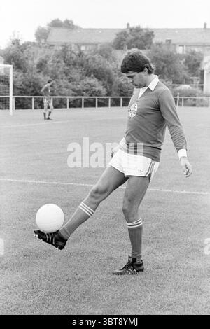 AAD van Engelen Spieler von VEW Football People and Trainer, Whizgle News, Dutch Desk, Niederlande, 1950 - 2000 am 11.08.1979. Dies sind die Elemente im Bild. In einer grasbewachsenen Umgebung steht ein männlicher Fußballspieler auf dem Spielfeld und konzentriert sich dabei auf einen weißen Ball, der vor ihm positioniert ist. Er trägt ein hellblaues langärmeliges Hemd mit einem runden Emblem auf der Brust und weiße Shorts mit roten und weißen Streifen, die senkrecht an den Seiten verlaufen. Sein Schuhwerk besteht aus dunklen Fußballstollen, die gut auf dem Gras sitzen. Der Hintergrund zeigt eine schwache Umrandung von Bäumen und Sträuchern Stockfoto