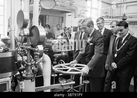 Eröffnung der Dampfpumpenstation auf halbem Weg durch Prince Claus Eröffnung der Öffnungen Inbetriebnahme der Dampfpumpenstation und der Dampfpumpenstation Halfweg, Whizgle News, Dutch Desk, Niederlande, 1950 - 2000 am 10-06-1987. Dies sind die Elemente im Bild. In einer geräumigen industriellen Umgebung mit hohen Decken und sichtbaren Rohren versammeln sich mehrere Personen um eine komplexe Maschinenanlage. Der Raum ist gut beleuchtet und bietet eine Mischung aus metallischen Oberflächen und industrieller Ausrüstung. Eine zentrale Figur in formellem Anzug und Krawatte konzentriert sich auf einen großen, rollenartigen Steuerungsmechanismus. Seine Haltung Stockfoto