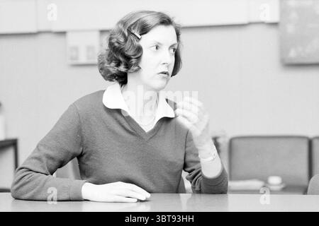 Porträt Ria Vaal Z.B. Haarlem Hospitals Haarlem Boerhaavelaan Niederlande, Whizgle News, Dutch Desk, Niederlande, 1950 - 2000 auf 14-01-1985. Diese Themen sind in der Abbildung dargestellt. In einem gut beleuchteten Innenbereich wird eine Frau mitten im Gespräch festgehalten, ihr Ausdruck ist animiert und nachdenklich. Sie hat mittellanges, welliges Haar, das mit einem seitlichen Clip gestylt ist, der ihrem Gesicht einen weichen Rahmen verleiht. Ihre Kleidung besteht aus einem dunklen, langärmeligen Pullover über einem Hemd mit Kragen, was eine Mischung aus lässigem und professionellem Stil andeutet. Die Hände der Frau sind ausdrucksvoll, während sie spricht, und sie verleiht ihr Dynamik Stockfoto