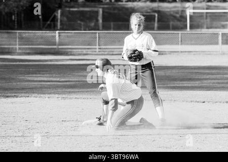Softball: Terrasvogels - HCAW, Whizgle News, Dutch Desk, Niederlande, 1950 - 2000 am 12.07.1996. Dies sind die Themen im Bild. In einer lebhaften Sportwelt spielen zwei Personen einen Moment auf dem Spielfeld. Die Szene wird von einem gut gepflegten Dreck-Infield dominiert, der von einem leichten Staub über die Basis gestreut wird, wo ein Spieler in einer bereit stehenden Position hockt. Dieser Spieler, der in einen schwarzen Baseballhelm und ein gestreiftes Trikot gekleidet ist, wirkt fokussiert und aufmerksam und zeigt einen entschlossenen Ausdruck. Ihr Trikot wird durch dunkle Hosen ergänzt, die sich von den Erdtönen des Bodens abheben. St Stockfoto