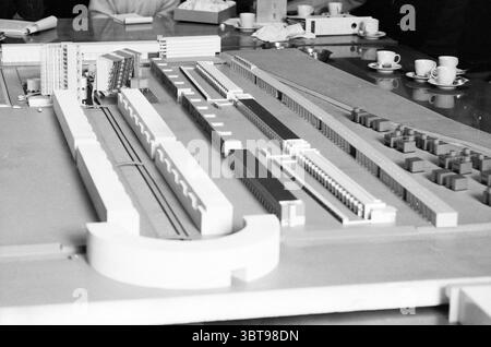 Meeting of Zuiderpolder Buildings Town Hall with Model Meetings, Whizgle News, Dutch Desk, Niederlande, 1950 - 2000 am 14.01.1987. Diese Themen sind in der Abbildung dargestellt. Die Szene zeigt ein detailliertes Architekturmodell auf einem Tisch, das die Aufmerksamkeit des Betrachters durch sein kompliziertes Design auf sich zieht. Das Modell besteht hauptsächlich aus weißen und grauen Materialien, die eine minimalistische Ästhetik betonen. Zahlreiche rechteckige Bauten, die Gebäude darstellen, sind linear angeordnet und zeigen verschiedene Maßstäbe und Orientierungen. Das Layout deutet auf eine geplante städtische Umgebung mit klarer Entschärfung hin Stockfoto