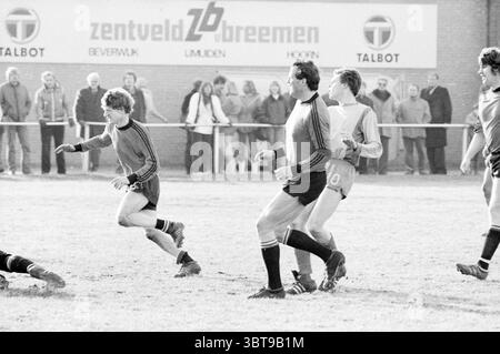 ODIN - de Kennemeren Football Odin, Whizgle News, Dutch Desk, Niederlande, 1950 - 2000 am 06-02-1982. Diese Themen sind in der Abbildung dargestellt. In dieser Sportszene findet auf einem grasbewachsenen Feld ein dynamisches Fußballspiel statt. Die Atmosphäre ist voller Spannung, während die Spieler mitten im Geschehen sind und ihre Sportlichkeit zum Ausdruck bringen. Im Vordergrund stehen zwei Spieler in Bewegung. Einer sprintet von einem Gegner weg und zeigt einen Blick der Entschlossenheit. Er trägt ein dunkles Trikot und Shorts, mit spürbarer Energie. Der gegnerische Spieler ist in leichteren Gang gekleidet und in einen offensichtlichen Versuch verwickelt Stockfoto