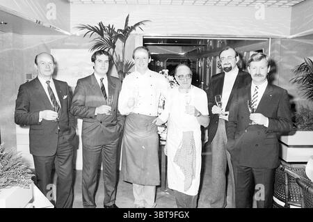 Deutsche Weinprobe Bokkedoorns Overveen. Wine Overveen, Whizgle News, Dutch Desk, Niederlande, 1950 - 2000 am 05-11-1984. Diese Themen sind in der Abbildung dargestellt. Die Szene zeigt eine Gruppe von sechs gut gekleideten Männern, die zusammen in einer raffinierten Umgebung stehen. Sie sind in einer Reihe angeordnet, jede mit einer Sektflöte, und ihre Ausdrucksformen vermitteln Feier und Kameradschaft. Von links ausgehend trägt die erste Person einen Nadelstreifenanzug mit Krawatte, der einen Hauch von Professionalität ausstrahlt. Neben ihm steht ein Mann in einem grauen Anzug im Kontrast zu seinem polierten Aussehen und etwas m Stockfoto