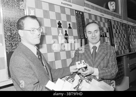Preisverleihung Großmeister HST Hochofen Chess Tournament Award Ceremony, Whizgle News, Dutch Desk, Niederlande, 1950 - 2000 am 02-02-1978. Dies sind die Themen im Bild. In einem gut beleuchteten Innenbereich stehen zwei Männer an vorderster Front und treten in einem Moment des freundlichen Austauschs ein. Eine Person, die in einem dunklen Anzug mit gemusterter Krawatte gekleidet ist, hält eine kleine Trophäe, während sie sie auf den anderen Mann ausdehnt, der einen karierten Blazer und ein Hemd mit Kragen trägt. Die Gesichtsausdrücke vermitteln ein Gefühl von Kameradschaft und Leistung, was auf eine jüngste Leistung im Kontext von a c hindeutet Stockfoto