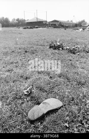 Installation von Rotorblättern an Windmühle Waarderpolder Haarlem Niederlande, Whizgle News, Dutch Desk, Niederlande, 1950 - 2000 am 12-06-1989. Die Abbildung zeigt diese Themen. Die Szene fängt eine ruhige Landschaft im Freien ein, dominiert von einer riesigen Grasfläche, die sich bis in den Hintergrund erstreckt. Das Gras ist ein gedämpfter Grünton, leicht bewachsen, durchsetzt mit braunen Böden, die auf ein weniger gepflegtes Gebiet hinweisen. Im Vordergrund befindet sich ein verlassenes, verwittertes Objekt, das einer Schuhsohle ähnelt, bedeckt mit einer dünnen Staubschicht, deren Farbe im Laufe der Zeit verblasste. Dieses Einzelstück fügt einen hinzu Stockfoto