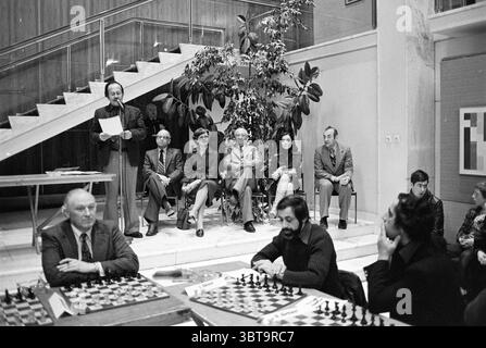 Schlussspiel + Preisverleihung Wijk aan Zee Blast Furnace Chess Tournament Prize Ceremony, Whizgle News, Dutch Desk, Niederlande, 1950 - 2000 am 27.01.1978. Dies sind die Themen im Bild. Die Szene entfaltet sich in einem Innenbereich, der von einer Mischung aus moderner Architektur und einer ruhigen Atmosphäre geprägt ist. Eine Treppe, elegant gestaltet mit einer Kombination aus schlanken Linien und glatten Oberflächen, steigt von vorne auf und führt zu einem geräumigen Bereich darüber. Der Raum ist gut beleuchtet und hebt die polierten Oberflächen hervor und wirft sanfte Schatten. In der Mitte ist eine Gruppe von Menschen an einer che beteiligt Stockfoto