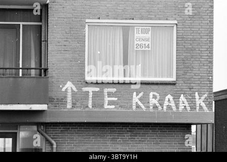 Houses for Squatting' in Zandvoort Kraken Zandvoort, Whizgle News, Dutch Desk, Niederlande, 1950 - 2000 am 10-03-1980. Diese Themen sind in der Abbildung dargestellt. Die Szene zeigt ein Wohngebäude, das sich durch seine Ziegelfassade auszeichnet, in warmen Orange- und Brauntönen. Ein Balkon erstreckt sich von der linken Seite und bietet einen Blick in einen Wohnbereich hinter einem großen Fenster. Das Fenster ist mit transparenten, hellen Vorhängen gekleidet, die das Umgebungslicht sanft abstrahlen und ein warmes, einladendes Leuchten erzeugen. Der Schwerpunkt der Komposition ist die Wand unter dem Balkon, die kräftig, ha zeigt Stockfoto