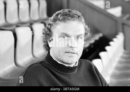 Ruud Geels Manager Telstar Football Telstar, Whizgle News, Dutch Desk, Niederlande, 1950 - 2000 am 29-03-1990. Diese Themen werden in der Abbildung angezeigt. Die Szene zeigt einen Mann mit lockigen Haaren, der in einem Innenbereich sitzt, wahrscheinlich in einer Sportarena oder einem Stadion. Er trägt einen dunklen Strickpullover, der seinem Aussehen einen Hauch von lässiger Raffinesse verleiht. Der Hintergrund zeigt eine Reihe leerer Sitzbänke, deren helle, in Reihen angeordnete Sitze ein Gefühl der Offenheit und vielleicht der Erwartung eines Ereignisses betonen. Die Beleuchtung im Raum ist weich und gestreut, was ein warmes und einladendes Ambiente schafft Stockfoto