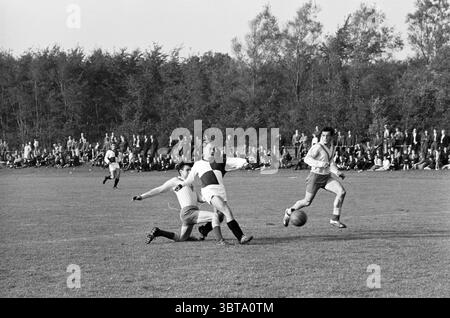 Lisse - VEP Football, Whizgle News, Dutch Desk, Niederlande, 1950 - 2000 am 04-10-1964. Diese Themen sind in der Abbildung dargestellt. In einer lebhaften Outdoor-Szene spielen zwei Teams ein intensives Fußballspiel auf einem breiten, grünen Feld. Das Gras ist lebhaft üppig und steht im Kontrast zu den scharfen Bewegungen der Spieler. Auf der linken Seite befindet sich ein Spieler in der Mitte des Rutsches und versucht, den Ball eines Gegners anzugreifen, um seine Leichtathletik und Entschlossenheit zum Ausdruck zu bringen. Er trägt ein dunkles Hemd und leichte Shorts. Seine Haltung unterstreicht die Dringlichkeit des Augenblicks. Der Gegner trägt ein weißes und rotes Trikot und ist in m Stockfoto
