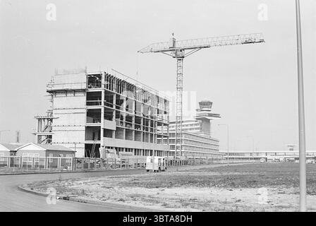 Bericht M.A.C. Schiphol Construction sites Neelissen J.P.A. Report, Whizgle News, Dutch Desk, Niederlande, 1950 - 2000 am 25-09-1967. Diese Themen werden in der Abbildung angezeigt. Die Szene zeigt eine Baustelle an einem klaren Tag, die sich durch ihre monochromatische Palette auszeichnet. Im Vordergrund ragt ein großer Baukran über das Gebäude, dessen Arm nach außen ausstreckt. Die charakteristische Struktur des Krans ist gegen den Himmel gerichtet, was ein Gefühl der Aufwärtsbewegung suggeriert. Links erhebt sich ein teilweise fertiggestelltes Gebäude mit mehreren Etagen. Die Betonkonstruktion Stockfoto