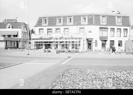 Hotel Terburg Beverwijk Hotels, Whizgle News, Dutch Desk, Niederlande, 1950 - 2000 am 03-04-1969. Diese Themen sind in der Abbildung dargestellt. Die Szene zeigt ein malerisches Hotel an einer Kreuzung mit einem charmanten, zweistöckigen Gebäude mit einem schrägen Dach. Seine Fassade zeigt eine Mischung aus hellen und dunklen Tönen, was ihm ein klassisches europäisches Aussehen verleiht. Große Fenster säumen die Vorderseite, die eine einladende Atmosphäre vermitteln, während sich Sitzbereiche im Freien entlang des Bürgersteigs erstrecken, die mit Tischen und Stühlen geschmückt sind und auf einen lebhaften sozialen Raum hinweisen. Die Umgebung des Hotels spiegelt eine ruhige Atmosphäre wider Stockfoto