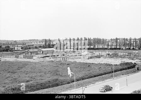 Construction Swimmingpool Lisse Construction Construction Pits, Whizgle News, Dutch Desk, Niederlande, 1950 - 2000 am 11-06-1968. Dies sind die Themen im Bild. Die Szene zeigt eine Baustelle vor dem Hintergrund einer weitläufigen Landschaft. Im Vordergrund befindet sich ein teilweise freigelegter Bereich mit Erd- und Baustoffhaufen, darunter Holzbalken und Stahlgerüste. Mehrere Betonfundamente treten aus dem Boden hervor, was auf die frühen Bauphasen hinweist. Auf der rechten Seite befindet sich eine schmale, kurvige Straße, die mit Lichtpfeilern gesäumt ist, die ein Gefühl der Sichtweise schafft Stockfoto