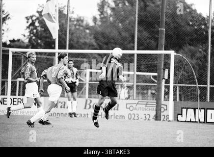 Fußball: EDO - Stormvogels Haarlem the Netherlands, Whizgle News, Dutch Desk, Niederlande, 1950 - 2000 am 13.09.1997. Diese Themen werden in der Abbildung angezeigt. Die Szene entfaltet sich auf einem grasbewachsenen Fußballfeld mit Action. Im Vordergrund stehen zwei Spieler in lebhaften Trikots im rasanten Spiel. Ein Spieler, der ein gestreiftes Oberteil in tiefrot und schwarz trägt, springt in die Luft und zeigt seine Leichtathletik. Sein Kopf ist rasiert, was seinen konzentrierten Ausdruck verstärkt. Der gegnerische Spieler, der in einem azurblauen Trikot mit einer Zahl gekleidet ist, sieht aufmerksam zu und ist bereit zu reagieren. Der Hintergrund zeigt einen goa Stockfoto