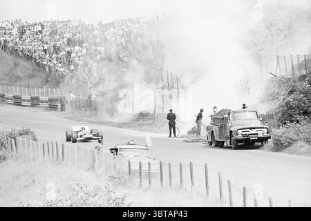 Feuer infolge des tödlichen Unfalls des 28-jährigen britischen Fahrers Piers Courage mit seinem Tomaso Ford im Zandvoort Grand Prix Zandvoort Burgemeester van Alphenstraat, Whizgle News, Dutch Desk, Niederlande, 1950 - 2000 am 21.06.1970. Das Bild enthält diese Themen. Die Szene zeigt einen dramatischen Moment bei einem Rennen, umgeben von einer rauchigen Atmosphäre. Im Hintergrund versammelt sich die Menge, deren unterschiedliche Silhouetten eine große Anzahl von Zuschauern anzeigen lassen. Sie scheinen fasziniert zu sein, einige lehnen sich nach vorne, während andere mit gekreuzten Armen stehen, alle scheinen sich auf die Entfaltung konzentriert zu sein Stockfoto