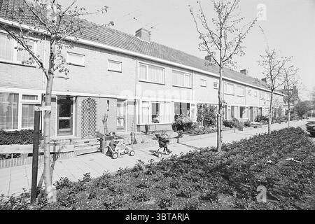Teylingen New Construction District Sassenheim Sassenheim, Whizgle News, Dutch Desk, Niederlande, 1950 - 2000 am 09-05-1972. Die Abbildung zeigt diese Themen. Die Szene zeigt eine ruhige Wohnstraße, gesäumt von geordneten Häusern. Jeder Wohnort weist einen ähnlichen architektonischen Stil auf, der durch Ziegelfassaden und eine Reihe rechteckiger Fenster mit Fensterläden gekennzeichnet ist. Die Häuser haben Gärten, die durch kleine Hecken und Blumenbeete Grün zeigen. Im Vordergrund befindet sich ein gepflegter Bürgersteig, der durch akribische Blumenbeete führt. Die Gartenarbeit ist sorgfältig angeordnet, mit lebendigen Pflanzen Stockfoto