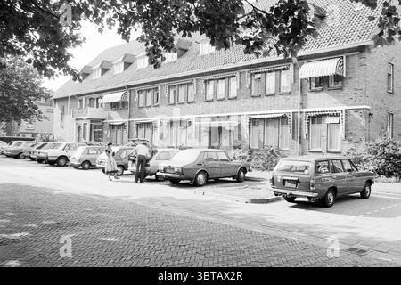 Externes Pflegeheim St Jozef Heemskerk Außenkrankenhäuser Heemskerk, Whizgle News, Dutch Desk, Niederlande, 1950 - 2000 am 08-09-1980. Das Bild enthält diese Themen. Die Szene zeigt ein Wohngebiet, das durch eine Reihe von zweistöckigen Backsteinhäusern gekennzeichnet ist. Diese Strukturen verfügen über mehrere Fenster mit gestreiften Markisen, die etwas Schatten spenden. Die Gebäude sind symmetrisch, was das geordnete Erscheinungsbild der Anlage verbessert. Im Vordergrund ist eine gepflegte Kopfsteinpflasterstraße mit mehreren dicht nebeneinander geparkten Autos gesäumt. Die Fahrzeuge unterscheiden sich in Marke und Modell und zeigen einen Rang Stockfoto