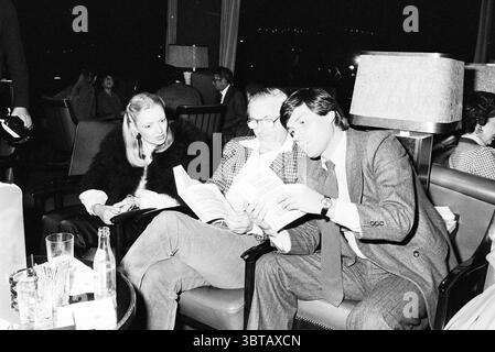 Buchpräsentation Schloss zwischen vier Wänden von Vladimir Bukovsky Amsterdam Apollolaan Niederlande, Whizgle News, Dutch Desk, Niederlande, 1950 - 2000 am 11-1979. Die Abbildung zeigt diese Themen. Die Szene findet in einer schwach beleuchteten Lounge statt, die ein elegantes Ambiente ausstrahlt. Die Möbel sind klassisch gestaltet und verfügen über dunkle Ledersessel und Holzakzente. Die eleganten Tischleuchten strahlen ein weiches, warmes Licht aus, das die Gesichter der sitzenden Personen hervorhebt. Drei Personen besetzen das Zentrum der Komposition. Auf der einen Seite eine Frau mit langen, blonden Haaren und einem stilvollen, da Stockfoto