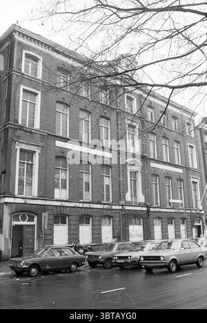 Außenbereich Anton de KOM Stadhouderskade 83-84 Amsterdam Stadhouderskade Niederlande, Whizgle News, Dutch Desk, Niederlande, 1950 - 2000 auf 30-01-1979. Diese Themen werden in der Abbildung angezeigt. Die Szene zeigt ein historisches Backsteingebäude im klassischen Architekturstil, das sich durch hohe, enge Fenster und eine symmetrische Fassade auszeichnet. Die Struktur hat einen reichen, warmen roten Farbton, der auf Alter und Tradition hinweist. Vor dem Gebäude parken mehrere Oldtimer dicht nebeneinander entlang der Straße. Diese Fahrzeuge zeigen eine Vielzahl von gedämpften Farben, überwiegend Grautöne und Stockfoto