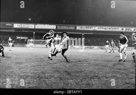 AZ'67 spielt in der dritten Runde des UEFA-Cups gegen den FK Radnički Niš (Jugoslawien) im de Alkmaarderhout-Stadion Alkmaar. Es wurde 5:0. Spiel Fußball. Alkmaar, Whizgle News, Dutch Desk, Niederlande, 1950 - 2000 am 10-12-1980. Diese Themen sind in der Abbildung dargestellt. Die Szene fängt während eines nächtlichen Spiels einen dynamischen Moment auf einem Fußballfeld ein. Die Umgebung wird durch Stadionlichter beleuchtet, wodurch ein starker Kontrast zwischen den hellen Lichtflecken und der umgebenden Dunkelheit entsteht. Im Vordergrund stehen zwei Spieler in einem intensiven Kampf um den Ball. Ein Spieler, gekleidet in eine Lichtkugel Stockfoto