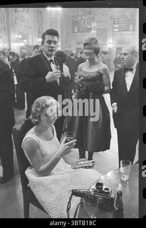Party nach der Galapremiere des Films „Makkers cease Your Wild Noise“ von Fons Rademakers im Lumièretheater in Rotterdam. Filmaufnahmen. Rotterdam, Whizgle News, Dutch Desk, Niederlande, 1950 - 2000 am 27-10-1960. Dies sind die Elemente im Bild. In einem üppigen Ballsaal findet ein lebhaftes geselliges Ereignis statt. Das Ambiente ist lebendig und doch raffiniert, geprägt von der eleganten Kleidung der Teilnehmer. Im Vordergrund sitzt eine junge Frau mit fließenden blonden Locken anmutig auf einem Stuhl. Sie trägt ein stilvolles, aufwändig gestaltetes Kleid, das sanft in der Umgebung glitzert Stockfoto