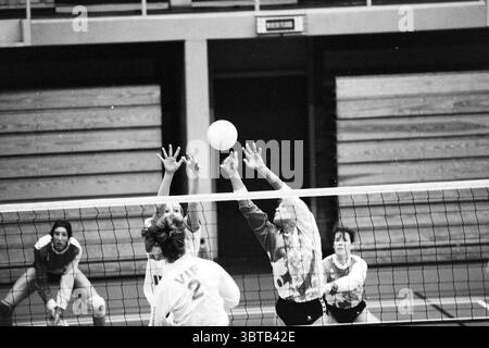 Volley-Ball; OVRA - VIF, Whizgle News, Dutch Desk, Niederlande, 1950 - 2000 am 29-10-1993. Diese Themen werden in der Abbildung angezeigt. In einem dynamischen Indoor-Volleyball-Setting fängt die Szene das Wesen eines Wettkampfes ein. Zwei Spieler aus den gegnerischen Teams springen, um einen schwebendem Volleyball zu blockieren, wobei die Arme mit intensivem Fokus nach oben reichen. Die Spieler tragen koordinierte Uniformen mit kontrastierenden Farben, die sie leicht zu erkennen machen. Das Spielfeld ist mit deutlichen Grenzlinien markiert, während das hohe Netz im Vordergrund die beiden Teams trennt. Ein Zuschauerbereich ist im Th sichtbar Stockfoto