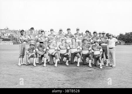 Team Mighty Meteors USA Baseball, Whizgle News, Dutch Desk, Niederlande, 1950 - 2000 am 19.07.1983. Dies sind die Elemente im Bild. Die Szene zeigt eine Gruppe von Individuen, die in zwei Reihen auf einem grasbewachsenen Feld angeordnet sind. Die Kulisse bietet einen klaren Himmel, der einen Tag voller heller Beleuchtung anzeigt und zu einer lebendigen und energiegeladenen Atmosphäre beiträgt. Im Vordergrund wird eine Mischung von Spielern präsentiert, die in passenden Uniformen gekleidet sind, die überwiegend helle und dunkle Farbtöne aufweisen. Die Farben sind in einer Mischung aus leuchtenden Gelb- und Blautönen gehalten und verfügen über ein auffälliges Logo Stockfoto