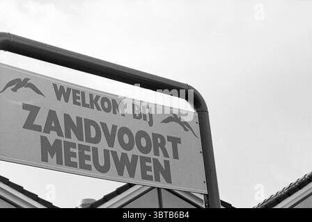 Fusion Football in Zandvoort Zandvoort, Whizgle News, Dutch Desk, Niederlande, 1950 - 2000 am 05-11-1996. Die Abbildung zeigt diese Themen. Die Szene zeigt ein einladendes Schild, das mit seiner markanten Struktur Aufmerksamkeit auf sich zieht. Das Schild verfügt über einen auffälligen Schriftzug, der den oberen Teil dominiert und von einem robusten schwarzen Stab eingerahmt wird, der einen Kontrast zum helleren Hintergrund bildet. Der Hintergrund zeigt einen dezenten, gedämpften Himmel, der auf einen bewölkten oder leicht bewölkten Tag hinweist und ein weiches Licht über die Gegend wirft. Die allgemeine Atmosphäre fühlt sich ruhig und einladend an, typisch für ein Meer oder eine Küstenlandschaft Stockfoto