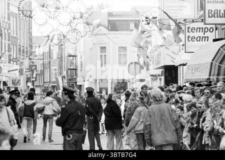 Zu Ehren von Yvonne van Gennip durch die Gemeinde HaarlemHaarlem unter dem Zauber von Yvonne 3x Gold Olympische Spiele Skating Haarlem Niederlande, Whizgle News, Dutch Desk, Niederlande, 1950 - 2000 am 02-03-1988. Das Bild enthält diese Themen. Die Szene zeigt eine belebte Straße voller Menschen. Sie sind auf beiden Seiten der Durchgangsstraße versammelt und schaffen eine lebhafte, energiegeladene Atmosphäre. Die Individuen tragen eine Mischung aus Freizeitkleidung, Mäntel und Jacken, die auf kühles Wetter hinweisen. Einige Leute unterhalten sich lebhaft, während andere die Umgebung beobachten Stockfoto