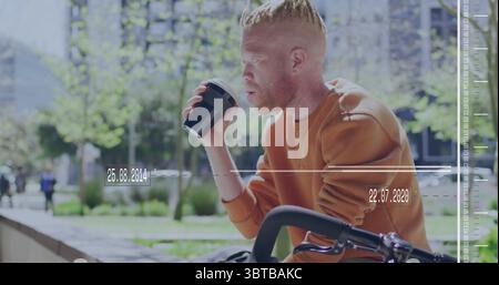 Radfahrer mit orangefarbenem Sweatshirt, schlürft aus einer schwarzen Kaffeetasse im Park plaza, mit Fahrrad, Felsvorsprung Stockfoto