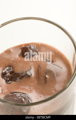 Schokoladenmilchform mit Eiswürfeln auf weißem Hintergrund Stockfoto