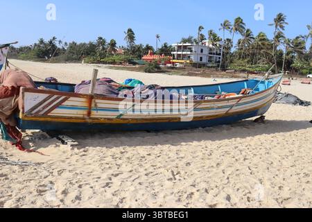 Ein kleines Boot ruht ruhig am Ufer, wo das Meer auf den Sand trifft. Stockfoto