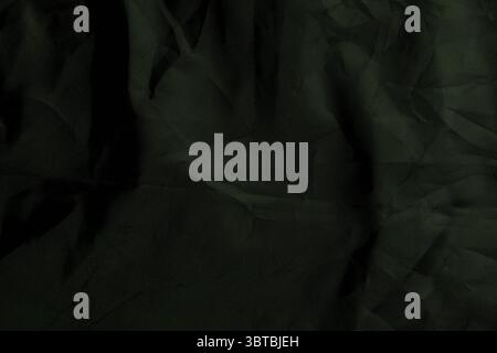 Dunkelgrüner, zerknitterter, rauer Leinwandstoff. Abstrakter farbiger Hintergrund Stockfoto