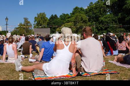 Zuschauer sehen das Wimbledon Mens Tennis Final zwischen Jannik Sinner und Carlos Alcaraz auf einer Großleinwand im Battersea Park bei heißem Sonnenschein am 13. Juli 2025 in London Stockfoto
