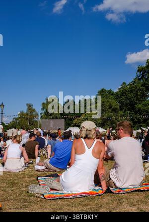 Zuschauer sehen das Wimbledon Mens Tennis Final zwischen Jannik Sinner und Carlos Alcaraz auf einer Großleinwand im Battersea Park bei heißem Sonnenschein am 13. Juli 2025 in London Stockfoto