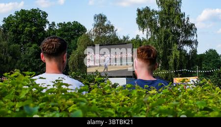 Zuschauer sehen das Wimbledon Mens Tennis Final zwischen Jannik Sinner und Carlos Alcaraz auf einer Großleinwand im Battersea Park bei heißem Sonnenschein am 13. Juli 2025 in London Stockfoto