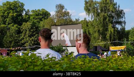 Zuschauer sehen das Wimbledon Mens Tennis Final zwischen Jannik Sinner und Carlos Alcaraz auf einer Großleinwand im Battersea Park bei heißem Sonnenschein am 13. Juli 2025 in London Stockfoto