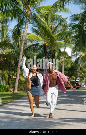 Reines Glück. Ein junges, vielseitiges, multiethnisches Paar genießt jeden Moment ihres tropischen Urlaubs Stockfoto