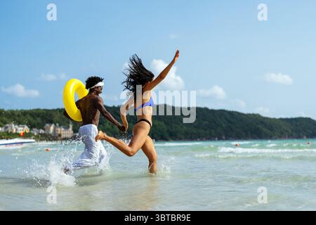 Reines Glück. Ein junges, vielseitiges, multiethnisches Paar genießt jeden Moment ihres tropischen Urlaubs Stockfoto