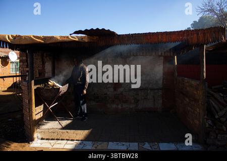 29. Juli 2020, Johannesburg, Gauteng, Südafrika: Ein Bewohner im Soweto Hostel bereitet sich auf das Braai vor (Bild: © Manash das/ZUMA Wire) Stockfoto
