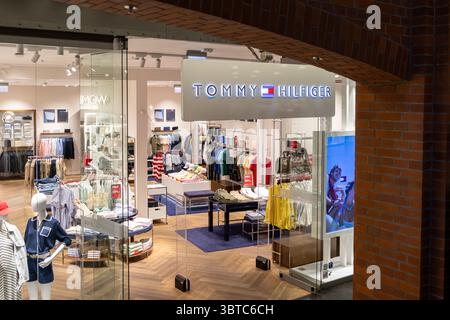 Posen, Polen - 30. Juni 2025: Tommy Hilfiger-Ladeneinrichtung mit stilvollen Ausstellungen von Kleidung, Accessoires und Schaufensterpuppen Stockfoto