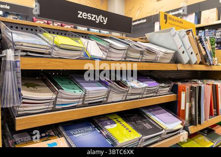 Posen, Polen - 30. Juni 2025: Regale mit einem „Notizbuch“-Schild („zeszyty“ auf Polnisch), gefüllt mit farbenfrohen akademischen Materialien und Schreibwaren Stockfoto