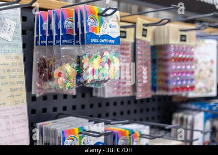 Posen, Polen - 30. Juni 2025: Verschiedene Taschen mit bunten schimmernden Pailletten und Konfetti werden in einem Verkaufsregal für kreative Zwecke ordentlich ausgestellt Stockfoto